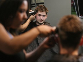 Spits centre Logan Brown stops by the Man's Shop for a hair cut from Pam Felton during a team promotional video. (TYLER BROWNBRIDGE/The Windsor Star)