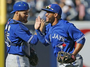 Toronto Blue Jays catcher Russell Martin, left, celebrates with second baseman Devon Travis after the Blue Jays defeated the New York Yankees 6-1 in an opening day game in New York Monday. (AP Photo/Kathy Willens)