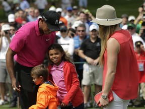 Lindsey Vonn , right, watches as Tiger Woods hugs his children Charlie, left and Sam during a practice round for the Masters Tuesday in Augusta. (AP Photo/Chris Carlson)