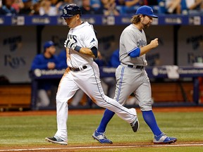 Tampa Bay Rays' Asdrubal Cabrera runs past Toronto Blue Jays pitcher R.A. Dickey before scoring on a sacrifice fly by Evan Longoria, during the fifth inning of a baseball game Friday, April 24, 2015, in St. Petersburg, Fla. (AP Photo/Mike Carlson)