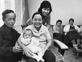 Members of the Nhon Thai family, who escaped from Vietnam in the rusty, overcrowded freighter Hai Hong last October, pose for a picture in the living room of their new home in the Windsor Housing Authority's St. Joseph Avenue housing project on Jan. 10, 1979.  Pictured above from left are Nhon Thai, his wife Quach Kim Tien with their grandchild Praharita, who was born on the Hai Hong, and Praharita's mother, Tran Ten Thai.  To the right are neighbours Pat Westwood, Jo-Anne Jones and Helen Demers who have helped the new family settle in.  (Windsor Star File Photo)