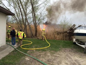 LaSalle firefighters work to put out a large grass fire at Acali Place Marina on Sunday, April 19, 2015. (Chris Thompson/TwitPic)