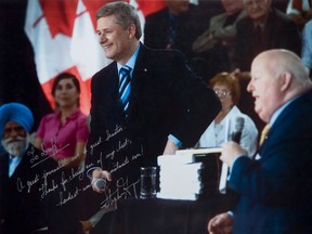 A signed PMO photo of Prime Minister Stephen Harper with suspended former Conservative Senator Mike Duffy, an exhibit of the defence, is shown at the trial of Mike Duffy on Thursday, April 9, 2015. Duffy is facing 31 charges of fraud, breach of trust, bribery, frauds on the government related to inappropriate Senate expenses.