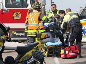 Emergency personnel tend to a driver of an electric bicycle that was struck by a car at the intersection of Wyandotte St. E. and Goyeau St. on Wednesday, April 15, 2015, in Windsor, ON. The accident occurred at 9:30 a.m. The man suffered a significant ankle injury. (DAN JANISSE/The Windsor Star)