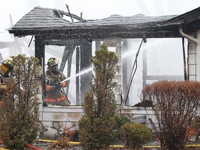 Essex Fire Rescue Services firefighters work on a house fire at a lakefront home at the Westchester Beach in Harrow, Ont. on Wednesday, April 8, 2015. (DAN JANISSE/The Windsor Star)
