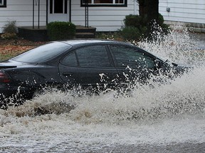 A car plows through the flooded street in the 1900 block of Buckingham Drive in Windsor on Monday, November 29, 2011. Wide spread flooding swept across the city due to heavy rain.                          (TYLER BROWNBRIDGE / The Windsor Star)