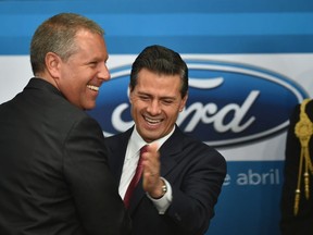 Mexican President Enrique Pena Nieto, right, and Ford's president for the Americas Joe Hinrichs greet each other on April 17, 2015. Ford announced a $2.5 billion plan to expand factories in Mexico to make next-generation engines and transmissions. (YURI CORTEZ/AFP/Getty Images)