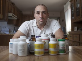 Flavio Celsi, 38, sits Friday, April 10, 2015, with a table full of  supplements and pills he takes for Lyme disease.  Celsi has started a GoFundMe campaign so he can receive treatment in Florida.  (DAX MELMER/The Windsor Star)