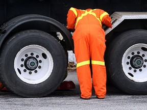 Files: A Ministry of Transportation Inspector conducts a mechanical inspection of a truck. (Windsor Star files)