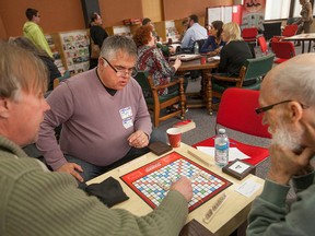 From left, Gerd Diestelmann, Peter Hrastovec, and Roger Coutts Umstead, play Scrabble at the Windsor Central Library's new Library Living Room, Saturday, April 25, 2015.  (DAX MELMER/The Windsor Star)