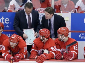 Detroit Red Wings head coach Mike Babcock right, talks to the team as assistant Andrew Brewer draws up a plan during the third period of Game 6 of a first-round NHL Stanley Cup hockey playoff series, Monday, April 27, 2015 in Detroit. The Lightning defeated the Red Wings 5-2 to force a Game 7. (AP Photo/Carlos Osorio)