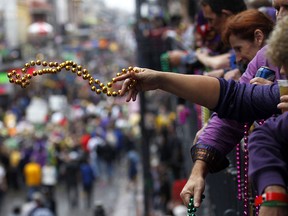 People throw beads from the balcony during Mardi Gras in New Orleans. (Associated Press files)