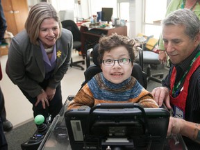Ned, a nine-year old student at the John McGivney Children's Centre, shows off his brand new communication device with his teacher, Jim Donohoo, to Andrea Horwath, leader of the Ontario New Democratic Party, Friday, April 10, 2015.  (DAX MELMER/The Windsor Star)