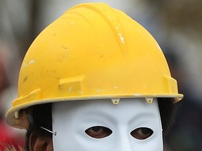 A man wearing a mask and construction helmet to represent workers killed on the job took part in a National Day of Mourning in this file photo. This year's ceremony will be held Tuesday.   (DAX MELMER/The Windsor Star)