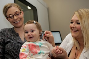 Paige Pierozynski, a Doctor of Audiology at The Hearing & Dizziness Clinic,examines a toddler in her office.
- Photo by Rick Dawes