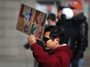 A man holds a sign stating 'Let Kids be Kids' at a rally at Charles Clark Square where approximately 100 people were protesting the province's new sex education curriculum, Saturday, April 4, 2015.  (DAX MELMER/The Windsor Star)