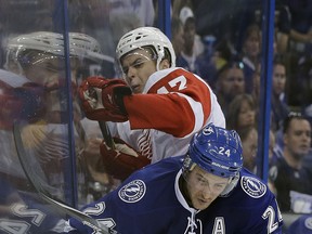 Tampa Bay Lightning right wing Ryan Callahan (24) checks Detroit Red Wings defenceman Alexei Marchenko (47) into the boards during the second period of Game 2 of a first-round NHL Stanley Cup hockey playoff series Saturday, April 18, 2015, in Tampa, Fla. (AP Photo/Chris O'Meara)