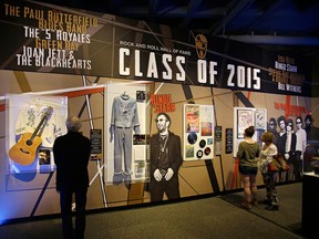 People look at the Class of 2015 exhibit at the The Rock and Roll Hall of Fame and Museum Friday, April 17, 2015, in Cleveland. Ringo Starr, who was previously enshrined with the Beatles in 1988, will be honored along with pop punks Green Day, soul singer-songwriter Bill Withers, underground icon Lou Reed, guitarist Stevie Ray Vaughan and Double Trouble, Joan Jett and The Blackhearts, The Paul Butterfield Blues Band and The "5" Royales. (AP Photo/Tony Dejak)