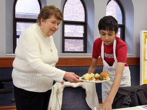 Students from the culinary arts program at the Westview Freedom Academy in Windsor, ON. were learning new skills on Thursday, April 23, 2015, while helping local senior citizens. The students prepared and served lunch to the seniors at the All Saints Church. Student Anan Alam, 14, serves a meal to Marj Armbrust, 90, during the event. (DAN JANISSE/The Windsor Star)