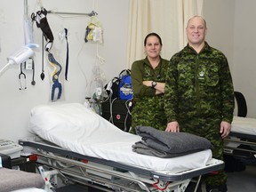 Lieut. Melinda Suich, a medic with 23 Field Ambulance, and Warrant Officer Dale Turner are shown the Unit Medical Station inside the Canadian Armed Forces Arctic Training Centre during NOREX 15 on March 26, 2015. (Courtesy of the Canadian Army)