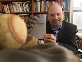 Dale Jacobs at his University of Windsor office, displays his new book, Sunday with the Tigers - Eleven ways to watch a game.  (JASON KRYK/The Windsor Star)