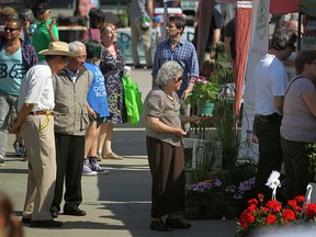 Customers browse the various booths on the opening day of the Downtown Farmer's Market at Charles Clark Square in downtown Windsor, Saturday, May 31, 2014. This year, customers will have the advantage of using their debit cards for transactions. (DAX MELMER / Windsor Star files)