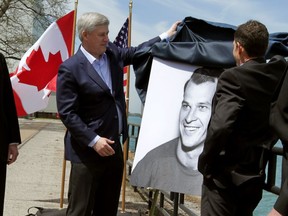 Michigan Gov. Rick Synder, left, Prime Minister Stephen Harper and Murray Howe, right, unveil a portrait of hockey legend Gordie Howe at Hiram Walkers Distillery in Windsor's Walkerville community where Harper announced the official name of new border crossing, Gordie Howe International Bridge, Thursday May 14, 2015. (NICK BRANCACCIO/The Windsor Star)