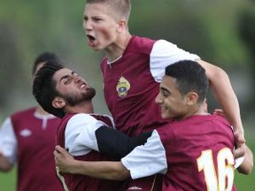 Catholic Central's Andrew Beaton, centre celebrates with teammates after scoring a penalty kick against Villanova during quarter-final boys high school soccer action at Villanova on May 11, 2015. (JASON KRYK/The Windsor Star)