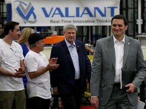 Prime Minister Stephen Harper, centre, is applauded as he and MP Jeff Watson, right, visit Valiant Corp. where he highlighted Canada's plan for manufacturers Thursday May 14, 2015. (NICK BRANCACCIO/The Windsor Star)