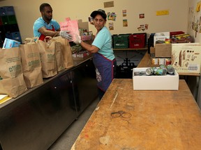 Volunteer Chris Reid, left, and kitchen support worker Pearl Dass sort recent food donations at Downtown Mission Monday May 18, 2015.  (NICK BRANCACCIO/The Windsor Star).