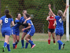 Walkerville Tartans Jaiden Lyons, centre, is congratulated by teammates Morden Cezanne (6) and Jessica Daskalakis, right, and others after scoring late in the first half against F.J. Brennan in senior girls soccer at Brennan field Monday May 19, 2015.  Brennan keeper Sydney Hryniw, left, and Hanna Straub react to the goal against. (NICK BRANCACCIO/The Windsor Star)