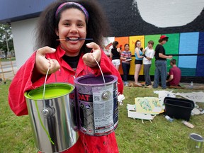 Art student Raeven Kohler-Jones, 15, displays vibrant colours as her classmates from Westview Freedom Academy apply paint to a wall art Aaron's Furniture on Tecumseh Road West Friday May 29, 2015. One of the purposes of the eco friendly mural is to combat graffiti with artistic expression. (NICK BRANCACCIO/The Windsor Star).