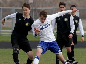 St. Anne Saints Dylan Satto, right, and Riverside Rebels Filip Vucicevic battle for the ball in second half at St. Anne High School Thursday April 30, 2015. (NICK BRANCACCIO/The Windsor Star)