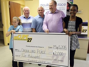 Rayanne Morrison (left) and Syieria Steuart (right) accept a cheque from CUPE Local 27 members Dan MacNeil, Jeff Ducharme and Bill Murray (left to right) at Drouillard Place in Windsor on Tuesday, May 5, 2015. The money will go to help send kids to camp. (TYLER BROWNBRIDGE/The Windsor Star)