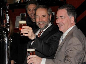 NDP Leader Tom Mulcair, centre, toast Walkerville Brewery with MP Brian Masse, right, and brewery owner Mike Brkovich, left, during a tour of Walkerville establishment Wednesday May 20, 2015.  (NICK BRANCACCIO/The Windsor Star).