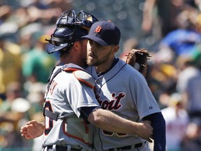 Detroit Tigers pitcher Joakim Soria, right, embraces catcher Bryan Holaday after the Tigers defeated the Oakland Athletics 3-2 in a baseball game, Wednesday, May 27, 2015, in Oakland, Calif. (AP Photo/George Nikitin)
