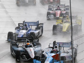 James Jakes of England, bottom left, slides into Tony Kanaan of Brazil on the first turn during the first race of the IndyCar Detroit Grand Prix auto racing doubleheader Saturday, May 30, 2015, in Detroit. (AP Photo/Dave Frechette)