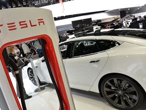 This January 14, 2014 firl photo shows the Tesla P85+ all electric car and its charging station  displayed at the North American International Auto Show in Detroit. (Stan HONDASTAN HONDA/AFP/Getty Images)