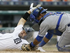 Detroit Tigers right fielder J.D. Martinez beats the tag of Kansas City Royals catcher Salvador Perez during the second inning of a baseball game, Friday, May 8, 2015, in Detroit. (AP Photo/Carlos Osorio)