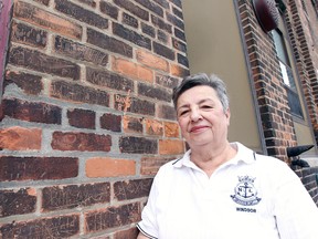 WINDSOR, ON. MAY 11, 2015. Shirley Beresford, president of the Navy League of Windsor poses next to back wall of the HMCS Hunter building on Ouellette Ave. on Monday, May 11, 2015 in Windsor, ON. The bricks have names of local sailors carved during the 1940s.  (DAN JANISSE/The Windsor Star)