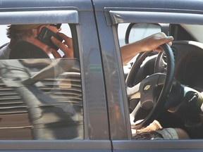 A driver talks on a cell phone while driving on Thursday, May 28, 2015, in downtown Windsor, ON.  (DAN JANISSE/The Windsor Star)