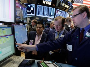 Specialist Patrick King, right, work with traders at his post on the floor of the New York Stock Exchange Friday, May 15, 2015. U.S. stocks are little changed in early trading a day after the Standard & Poor's 500 index closed at an all-time high. (AP Photo/Richard Drew)