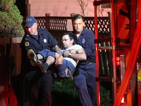 Windsor Firefighters rescue one of two victims from a house fire in the 500 block of Church St.  in Windsor, Ontario on May 6, 2015. (JASON KRYK/The Windsor Star)