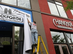 A media conference was held on Monday, May 25, 2015, announcing the relocation of the Hackforge group in downtown Windsor, ON. The technology organization will use the commercial space at 255 Ouellette Ave. which is part of a restaurant and bar ownership group. Mark Boscariol, landlord for the property unveils the Hackforge sign during the event.  (DAN JANISSE/The Windsor Star)