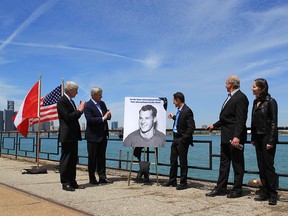 Michigan Gov. Rick Snyder, left, Prime Minister Stephen Harper, Murray Howe, Marty Howe and Cathy Howe, Gordie Howe's children, announce that the Detroit River International Crossing will be named the Gordie Howe International Bridge, on the waterfront, in Windsor, Ontario, Thursday May 14, 2015. THE CANADIAN PRESS/Dave Chidley