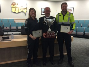 Paramedics Tricia Rousseau, left, and Chris Kirwan, right, were presented certificates of appreciation by Essex Windsor Emergency Medical Service Chief Bruce Krauter Wednesday at the Essex County Council meeting. Krauter is holding the trophy won by Rousseau and Kirwan, who took first place in the Advanced Care Paramedics division at the 2015 National Paramedic Competition in Durham County in April. (JULIE KOTSIS/The Windsor Star)