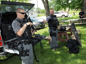 Const. Paul Paterson and Const. Marco Carbone (right) show off some of the equipment and weapons the ESU officers use during a police demonstration at Maryvale in Windsor on Thursday, May 28, 2015.              (TYLER BROWNBRIDGE/The Windsor Star)