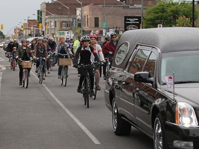 Cyclists follow a hearse down Wyandotte Street east during the Ride of Silence, an annual memorial dedicated to those who have been injured or killed while riding their bicycles.