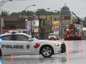 Crews work to right a utility pole on Tecumseh Road East at Walker Road following a thunderstorm on May 26, 2015. Windsor Police diverted traffic in the eastbound lanes of Tecumseh Road and Windsor Fire Service assisted on the scene.    (JASON KRYK/The Windsor Star)