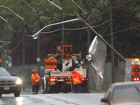 Crews work to right a utility pole on Tecumseh Road East at Walker Road following a thunderstorm on May 26, 2015. Windsor Police diverted traffic in the eastbound lanes of Tecumseh Road and Windsor Fire Service assisted on the scene.    (JASON KRYK/The Windsor Star)